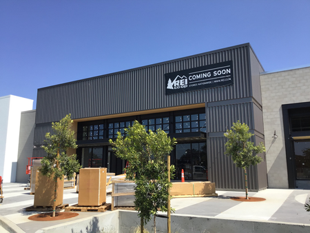 REI storefront with trees and shrubbery